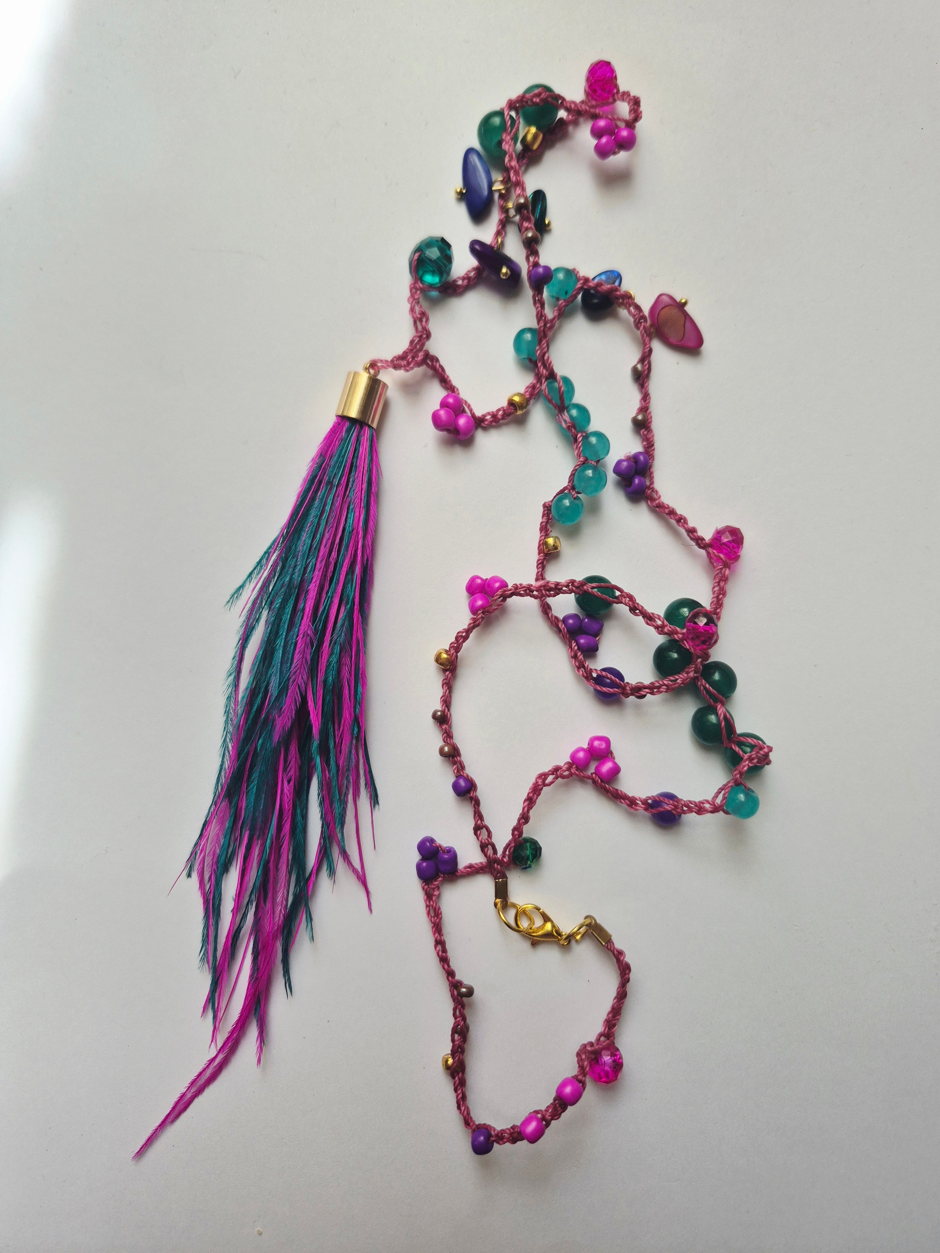 Collar tejido a crochet con mostacillas y plumas turquesa y fucsia